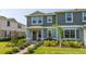 Inviting two-story townhome with well-manicured lawn and landscaped walkway leading to the covered porch at 13452 Sagestone Dr, Winter Garden, FL 34787
