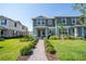 Inviting two-story townhome with lush green lawn and neatly trimmed bushes lining the brick-paved walkway at 13452 Sagestone Dr, Winter Garden, FL 34787