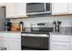Close-up of the kitchen featuring stainless steel appliances, granite countertops, and white cabinets at 13452 Sagestone Dr, Winter Garden, FL 34787