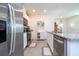 Bright kitchen with stainless steel appliances, white cabinetry, a granite countertop island, and tile flooring at 13452 Sagestone Dr, Winter Garden, FL 34787