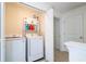 Convenient upstairs laundry area with a white washer and dryer and built in shelving at 13452 Sagestone Dr, Winter Garden, FL 34787