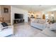 Open-concept living room showcasing neutral tones, stylish furniture, and seamless flow to the kitchen at 13452 Sagestone Dr, Winter Garden, FL 34787