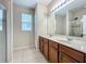 Bathroom featuring a double sink vanity with granite countertops and tile flooring at 13842 Pickett Reserve Ct, Orlando, FL 32826