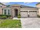 Charming home featuring a two car garage, stone accents, and well-manicured front yard with lush green grass at 13842 Pickett Reserve Ct, Orlando, FL 32826