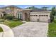 Charming home with a two car garage, brick driveway, stone accents, and landscaped front yard at 13842 Pickett Reserve Ct, Orlando, FL 32826
