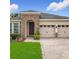 Inviting single-Gathering home with stone accents, a two-car garage, and a well-manicured lawn at 13842 Pickett Reserve Ct, Orlando, FL 32826