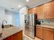 Stylish kitchen with stainless steel refrigerator, granite countertops, and wood cabinets at 13842 Pickett Reserve Ct, Orlando, FL 32826