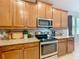 Bright kitchen featuring stainless steel appliances, granite countertops, and classic wood cabinetry at 13842 Pickett Reserve Ct, Orlando, FL 32826