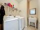 Functional laundry room with modern washer and dryer, utility sink, and storage shelves at 13842 Pickett Reserve Ct, Orlando, FL 32826