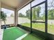 This screened in patio offers views of the green backyard and features artificial grass at 13842 Pickett Reserve Ct, Orlando, FL 32826