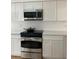 Modern kitchen features stainless steel microwave, stove and oven with white cabinetry at 1422 Spalding Rd, Winter Springs, FL 32708