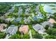 Captivating aerial view of a residential neighborhood featuring houses with private pools and lush green landscapes near a tranquil lake at 1453 Langham Ter, Lake Mary, FL 32746