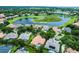 Aerial view of a neighborhood, featuring a home with a terracotta roof, a screened-in pool, and a scenic lake at 1453 Langham Ter, Lake Mary, FL 32746