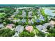 Expansive aerial view of a community with lush landscaping, swimming pools, and houses, surrounded by scenic lakes and trees at 1453 Langham Ter, Lake Mary, FL 32746