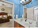 Bright blue bathroom with double sinks and view into bedroom at 1453 Langham Ter, Lake Mary, FL 32746