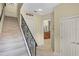 Inviting hallway leading to the staircase and kitchen, featuring tile flooring at 1453 Langham Ter, Lake Mary, FL 32746