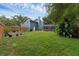 A spacious backyard with a screened in lanai, mature trees, and a privacy fence at 1610 Owl Ridge Ct, Apopka, FL 32712