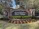 Well-maintained entrance sign with brick pillars and manicured landscaping welcomes residents to Sweetwater Park Village at 1610 Owl Ridge Ct, Apopka, FL 32712