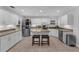 Well-lit kitchen featuring white cabinets, granite countertops, stainless steel appliances, and center island with barstools at 1610 Owl Ridge Ct, Apopka, FL 32712