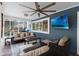 Cozy screened-in porch featuring comfortable seating, a ceiling fan, and a mounted TV for outdoor entertainment at 1610 Owl Ridge Ct, Apopka, FL 32712