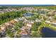An aerial view of a community with homes surrounded by lush greenery and a serene lake at 1803 Meadow Pond Way, Orlando, FL 32824
