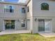 Back exterior showcasing a tiled patio, sliding glass doors, and exterior lighting, blending indoor-outdoor living at 1803 Meadow Pond Way, Orlando, FL 32824