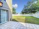 View of the backyard featuring a white fence, tile patio, and sliding glass doors leading to the home at 1803 Meadow Pond Way, Orlando, FL 32824
