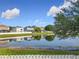 Backyard with a pond view showcases a well-kept lawn, white picket fence, and a tranquil water feature at 1803 Meadow Pond Way, Orlando, FL 32824