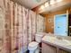 Bathroom features a toilet, sink, mirror, vanity and shower behind a patterned curtain at 1803 Meadow Pond Way, Orlando, FL 32824