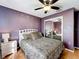 Bedroom featuring a bed, mirrored closet doors, and hardwood floors at 1803 Meadow Pond Way, Orlando, FL 32824