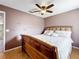 Cozy bedroom features a wood-framed bed, ceiling fan, and light-colored wood floors at 1803 Meadow Pond Way, Orlando, FL 32824