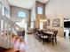Elegant dining room with soaring ceilings, chandelier, and stylish staircase leading to the second floor at 1803 Meadow Pond Way, Orlando, FL 32824