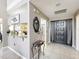 Inviting foyer features a decorative mirror, tile flooring, and access to the kitchen and front entrance at 1803 Meadow Pond Way, Orlando, FL 32824