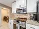 Modern kitchen featuring granite countertops, stainless steel appliances, and white cabinets at 1803 Meadow Pond Way, Orlando, FL 32824