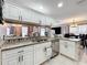 Updated kitchen with stainless steel dishwasher, granite counters, and white cabinetry overlooking living area at 1803 Meadow Pond Way, Orlando, FL 32824