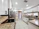 Modern kitchen with stainless steel appliances, granite countertops, and white cabinetry, perfect for culinary enthusiasts at 1803 Meadow Pond Way, Orlando, FL 32824