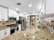 Bright kitchen featuring granite countertops, white cabinets, and stainless steel appliances at 1803 Meadow Pond Way, Orlando, FL 32824