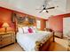 Bright main bedroom features a king bed, ceiling fan, and natural light from two windows at 1803 Meadow Pond Way, Orlando, FL 32824