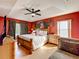 Bright main bedroom features a king bed, ceiling fan, and natural light from two windows at 1803 Meadow Pond Way, Orlando, FL 32824