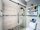 Modern shower features decorative stone floor, glass door, gray tile and decor shelving at 1803 Meadow Pond Way, Orlando, FL 32824