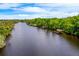 Aerial view of river with docks and lush greenery against a blue sky with clouds at 20 Twelve Oaks Trl, Ormond Beach, FL 32174