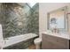 Modern bathroom with a bathtub featuring herringbone tile surround, a shower, and updated sink and mirror at 20 Twelve Oaks Trl, Ormond Beach, FL 32174