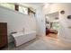 Modern bathroom with a freestanding tub, wood accent wall and large windows providing natural light at 20 Twelve Oaks Trl, Ormond Beach, FL 32174