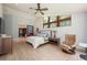 Comfortable bedroom with wood floors, a cozy chair, and view through oversized windows at 20 Twelve Oaks Trl, Ormond Beach, FL 32174