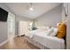Bright bedroom featuring light wood floors, white furniture, and a view of the outdoor greenery at 20 Twelve Oaks Trl, Ormond Beach, FL 32174