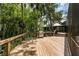 Spacious wooden deck with stainless steel grill surrounded by lush greenery and trees at 20 Twelve Oaks Trl, Ormond Beach, FL 32174