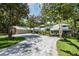 Spacious home with a large driveway, mature trees, and a three-car garage, offering ample parking and curb appeal at 20 Twelve Oaks Trl, Ormond Beach, FL 32174