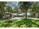 Charming brick home featuring a metal roof, mature trees, a circular driveway and lush landscaping at 20 Twelve Oaks Trl, Ormond Beach, FL 32174