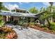 Landscaped front yard with stone walkway leading to a modern home with large windows and distinctive architectural details at 20 Twelve Oaks Trl, Ormond Beach, FL 32174