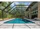 Covered outdoor pool area with lounge seating and a beautiful view of the backyard at 20 Twelve Oaks Trl, Ormond Beach, FL 32174